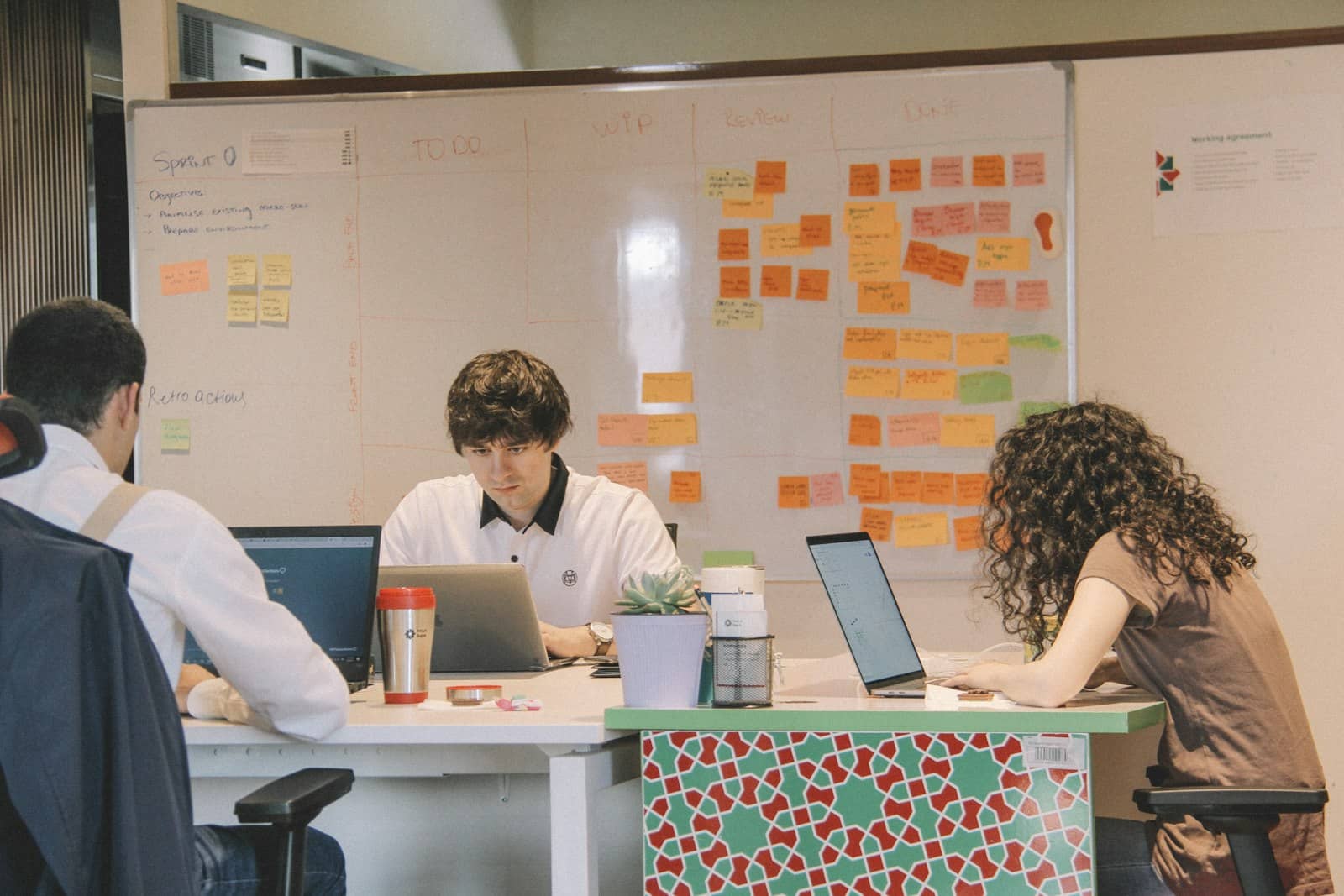 A creative team reviewing work together at a desk