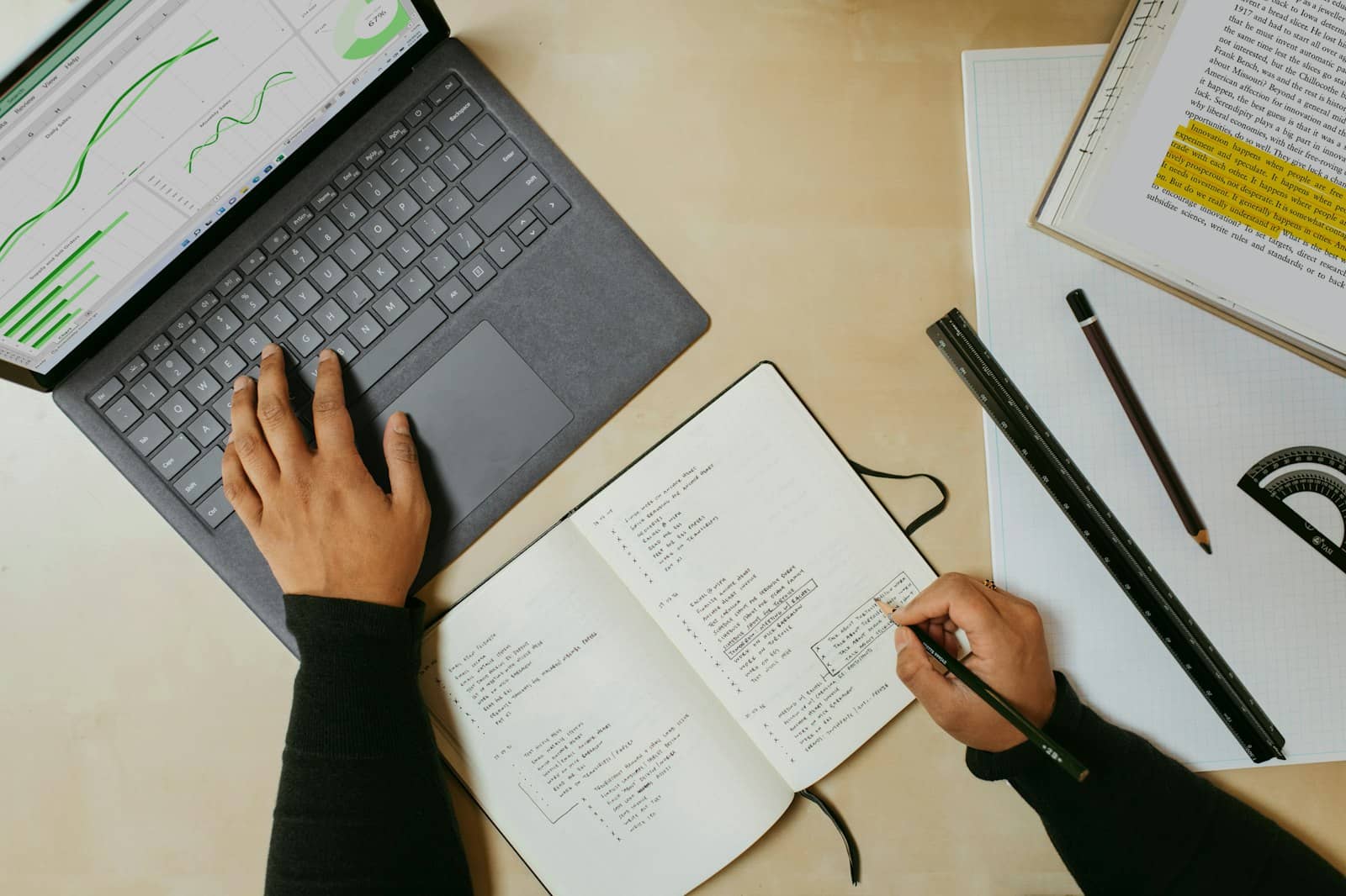 Two people planning a project together at a table with a laptop and notes