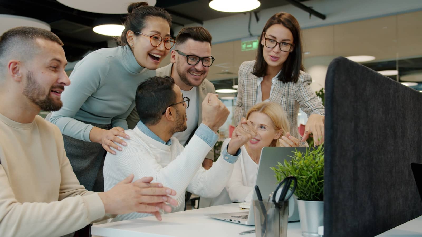 A team collaborating around a laptop